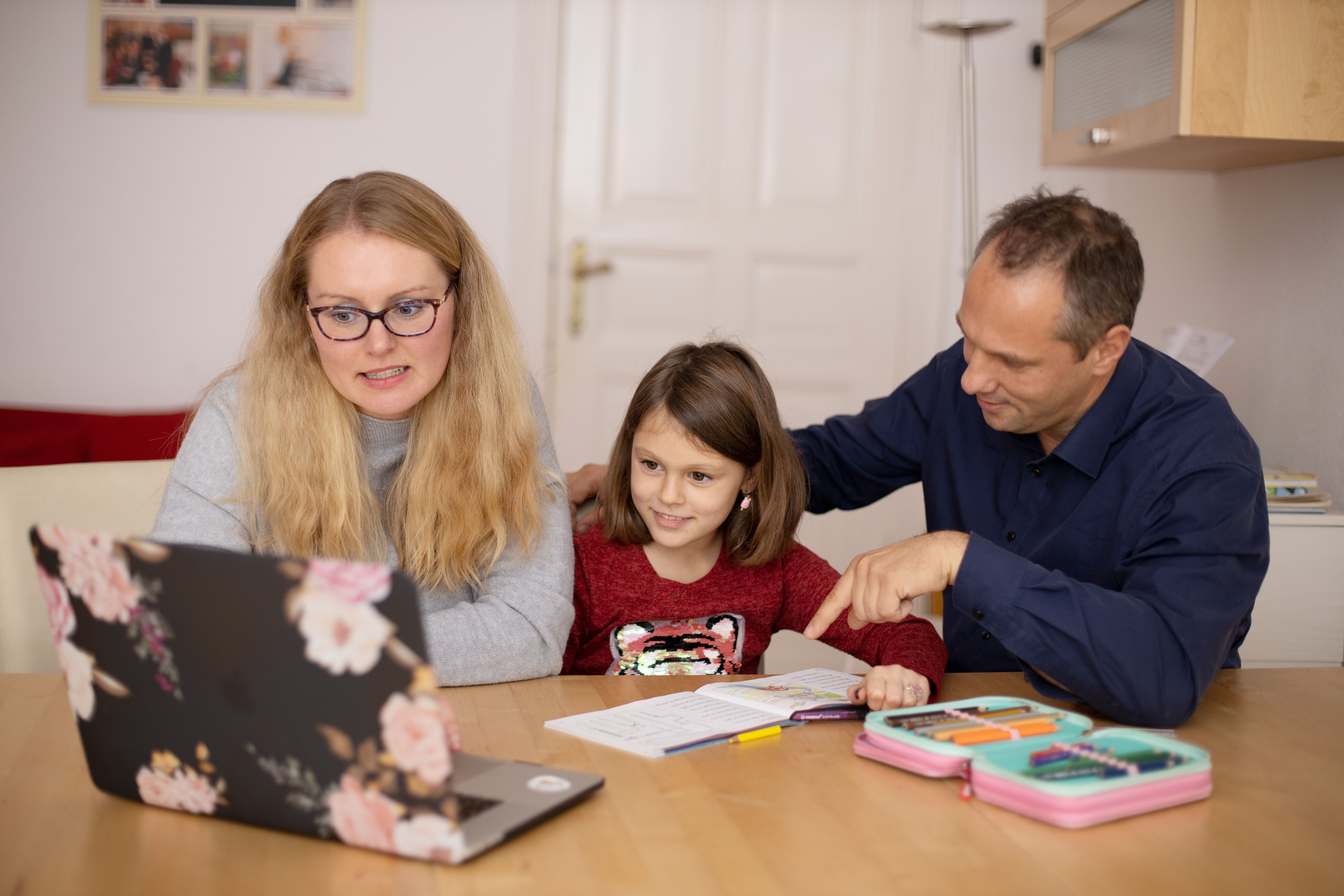 A parent and child working through maths worksheets together